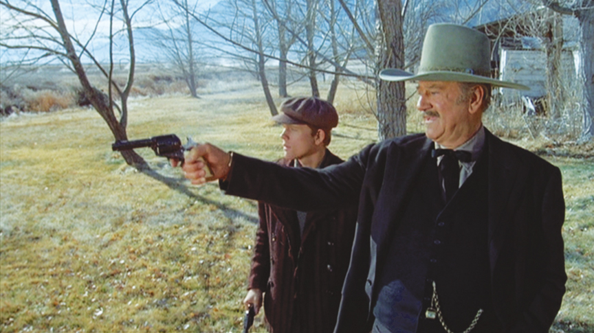 J.B. Books (John Wayne) gives Gillom Rogers (Ron Howard) a shooting lesson.