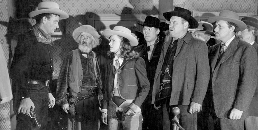 Things look bad for Rocklin, at a murder scene more crowded than a Charlie Chan drawing room. From left: John Wayne, George "Gabby" Hayes, Ella Raines, Ward Bond, Emory Parnell and Donald Douglas.